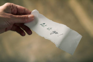 a woman holds a piece of paper that says let it go