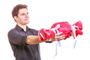 a man holds a poorly wrapped present
