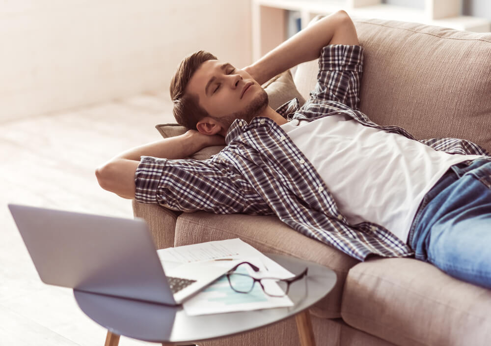 a man relaxes on a couch thinking about signs of cocaine abuse