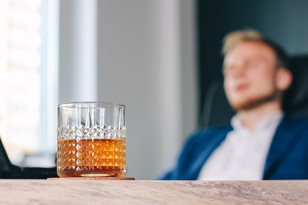 Man asleep at his desk thanks to alcohol withdrawal symptoms